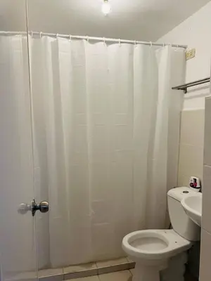 a bathroom with a white shower curtain and a toilet at Cozy Studio in Paraaque - Perfect for Transients and Long-Stayers Alike in Manila