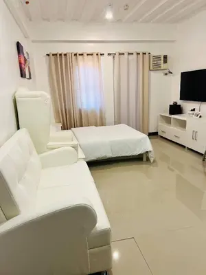 a hospital room with two beds and a tv at Cozy Studio in Paraaque - Perfect for Transients and Long-Stayers Alike in Manila