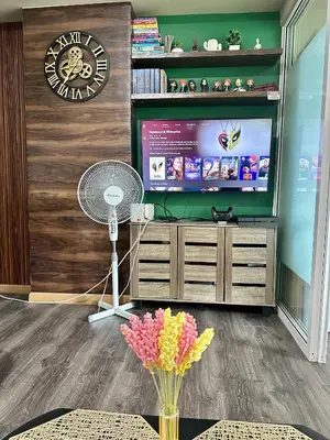 a living room with a television and a fan at Condo near airport with PS4 and Parking in Manila