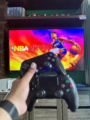 a person holding a video game controller in front of a tv at Condo near airport with PS4 and Parking in Manila