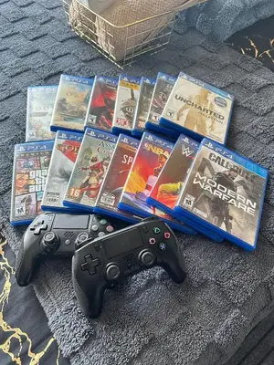 two video game controllers sitting next to a pile of books at Condo near airport with PS4 and Parking in Manila