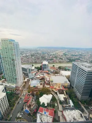an aerial view of a city with tall buildings at One Eastwood with mountain view in Manila