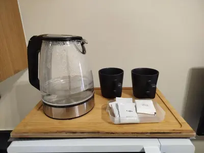 a blender sitting on a cutting board with two cups at Classy and Cozy Staycation near MOA in Manila