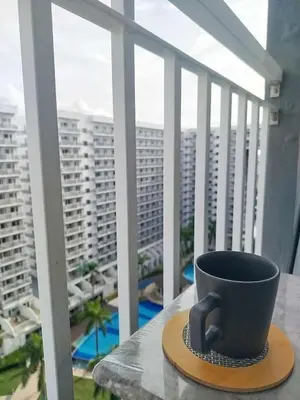 a coffee cup sitting on a table on a balcony at Classy and Cozy Staycation near MOA in Manila