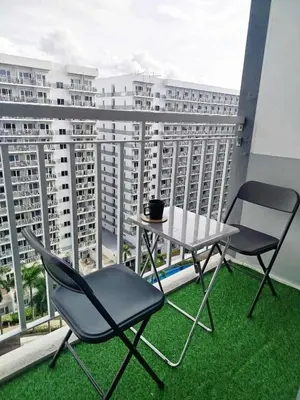 a table and two chairs on a balcony with a view at Classy and Cozy Staycation near MOA in Manila