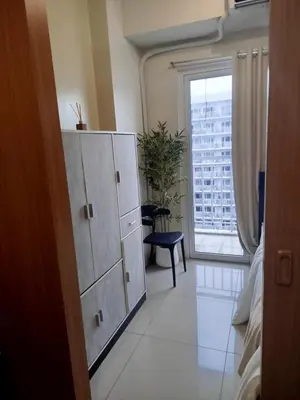 a bedroom with a large cabinet and a window at Classy and Cozy Staycation near MOA in Manila