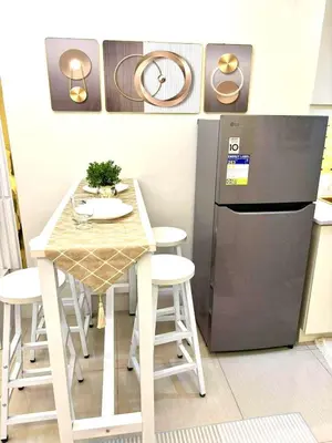 a small kitchen with a table and a refrigerator at Bai Labi Luxury Lounge in Manila