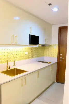 a kitchen with white cabinets and a sink at Bai Labi Luxury Lounge in Manila