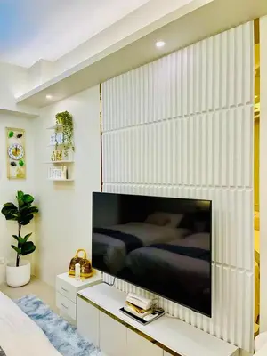 a bedroom with a large flat screen tv on a wall at Bai Labi Luxury Lounge in Manila