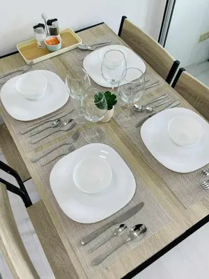 a table with white plates and wine glasses on it at B&T Azure Staycation - Parañaque in Manila
