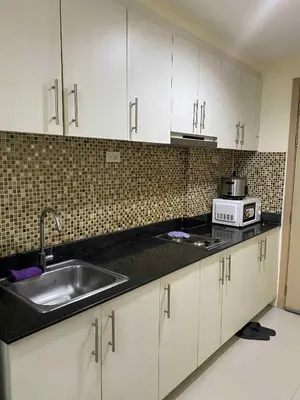 a kitchen with a sink and a microwave at The Tenth Balcony in Manila