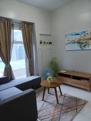 a living room with a couch and a table at Niu Ohana Ortigas Apartments and Residences in Manila