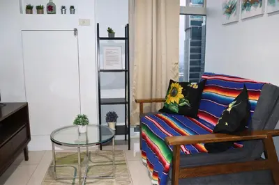 a living room with a couch and a glass table at Niu Ohana Ortigas Apartments and Residences in Manila