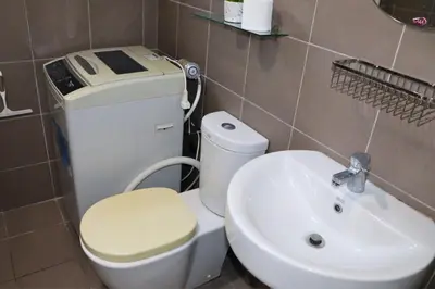 a bathroom with a toilet and a sink at Niu Ohana Ortigas Apartments and Residences in Manila