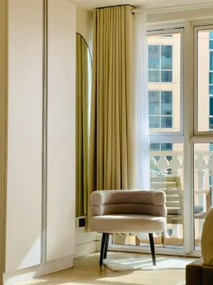 a living room with a chair and a window at Casa Elisae l Venice Grand Canal Mall Access in Manila