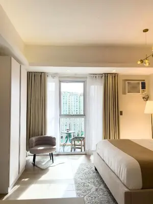 a hotel room with a bed and a window at Casa Elisae l Venice Grand Canal Mall Access in Manila