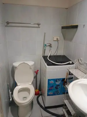 a bathroom with a toilet and a sink at AilynSea residence staycation in Manila