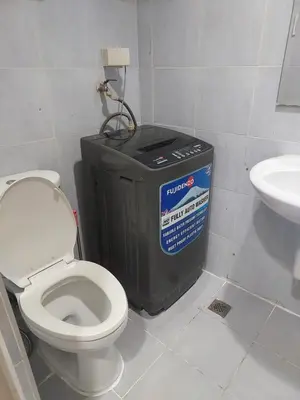a bathroom with a toilet and a trash can at AilynSea residence staycation in Manila