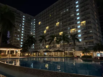 a swimming pool in front of a hotel at night at 349B by Premiere Haven Shell Residences in Manila