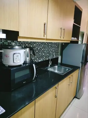 a kitchen with a sink and a toaster and a microwave at 349B by Premiere Haven Shell Residences in Manila