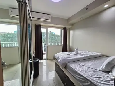 a bedroom with a bed and a large window at 349B by Premiere Haven Shell Residences in Manila