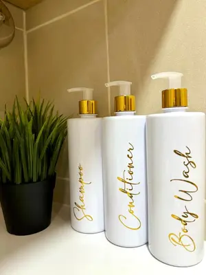 three white bottles sitting on a counter with a plant at Mujihomes - 1BR SMDC Fame Residences Mandaluyong in Manila