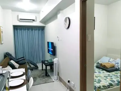 a living room with a room with a bed and a tv at Shore 3 Residences Condo with Netflix and Wifi in Manila