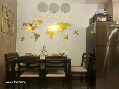 a table and chairs with a map of the world on a wall at Staycation near MOA, SMX Convention, DFA, NAIA in Manila