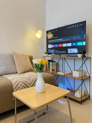 a living room with a vase of flowers on a coffee table at SMDC Light Residences - Studio Condo Unit in Manila