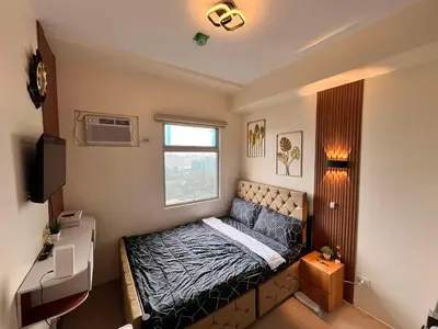 a small bedroom with a bed and a window at Mars Condo Unit in Manila
