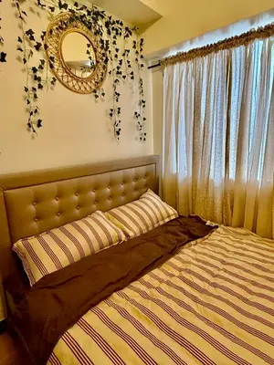 a bedroom with a bed with a mirror on the wall at YourSafeHaven in Manila