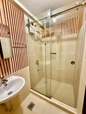 a bathroom with a shower and a sink at YourSafeHaven in Manila