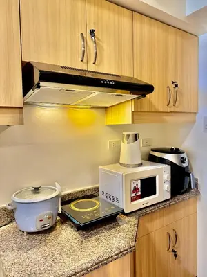 a kitchen counter with a microwave and a toaster oven at YourSafeHaven in Manila