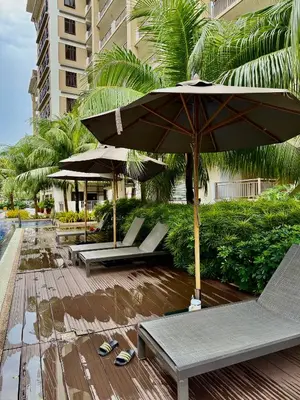 a patio with chairs and umbrellas on a beach at YourSafeHaven in Manila