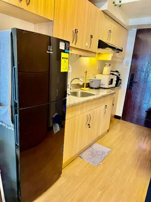 a kitchen with a black refrigerator and a sink at YourSafeHaven in Manila