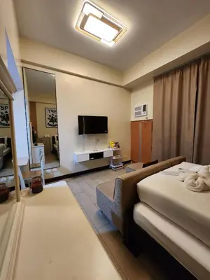 a hotel room with a bed and a television at Two Palm Tree Villas Across NAIA Terminal 3 in Manila