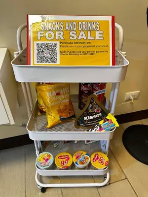 a refrigerator shelf with snacks and drinks for sale at Two Palm Tree Villas Across NAIA Terminal 3 in Manila