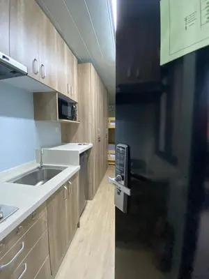 a kitchen with wooden cabinets and a sink at Sunrise Dormitel in Manila
