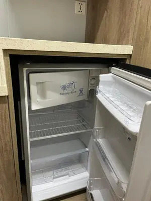 an empty refrigerator with its door open in a kitchen at Sunrise Dormitel in Manila