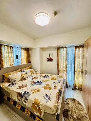 a bedroom with a bed with a comforter on it at Condo in Manila in Manila