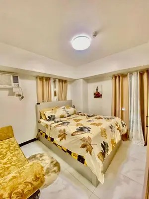 a bedroom with a bed and a chair at Condo in Manila in Manila