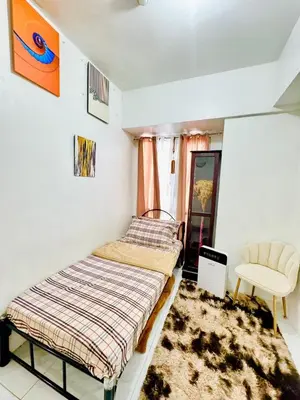 a bedroom with a bed and a chair in it at Condo in Manila in Manila