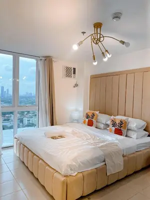 a bedroom with a large bed with a large window at Apartment in Pasig-khairo Residences in Manila