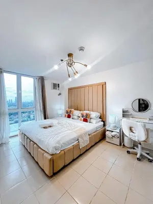 a bedroom with a large bed and a desk at Apartment in Pasig-khairo Residences in Manila