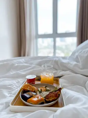 a tray with a plate of food on a bed at Apartment in Pasig-khairo Residences in Manila