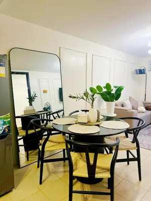 a dining room with a table and chairs and a couch at Apartment in Pasig-khairo Residences in Manila