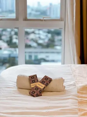 a pair of towels on a bed with a window at Apartment in Pasig-khairo Residences in Manila