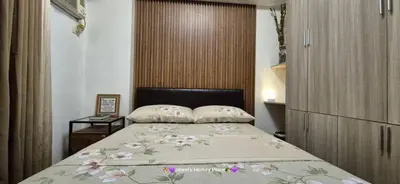 a bedroom with a large bed with flowers on it at JeweIs Homey Place -2br in a resort-like condo in Manila