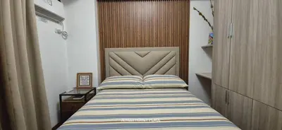 a bedroom with a bed with a striped blanket at JeweIs Homey Place -2br in a resort-like condo in Manila