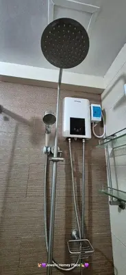 a shower in a room with a table and a machine at JeweIs Homey Place -2br in a resort-like condo in Manila